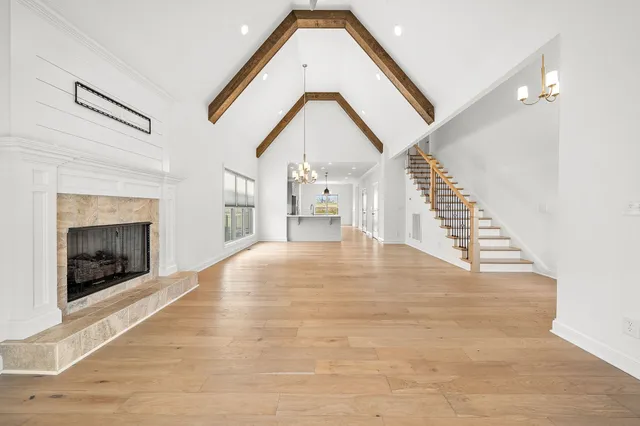 a view of empty room with wooden floor and fireplace
