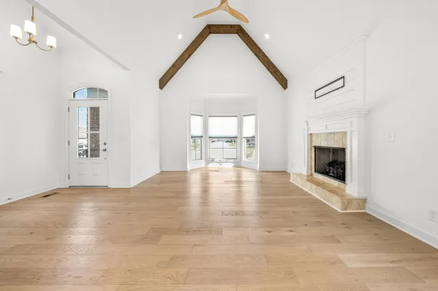 an empty room with windows and fireplace