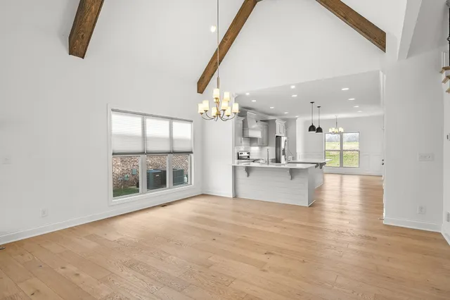 a view of an empty room with kitchen view and a window
