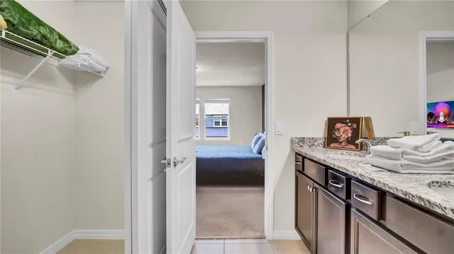 a bathroom with a granite countertop sink a mirror and a shower