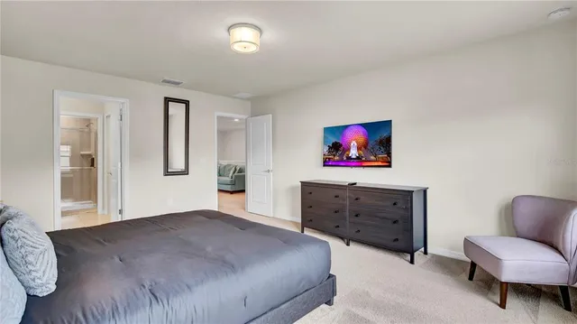 a bedroom with a bed painting on wall and a window