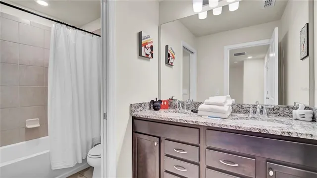 a bedroom with two beds and a dresser next to a window