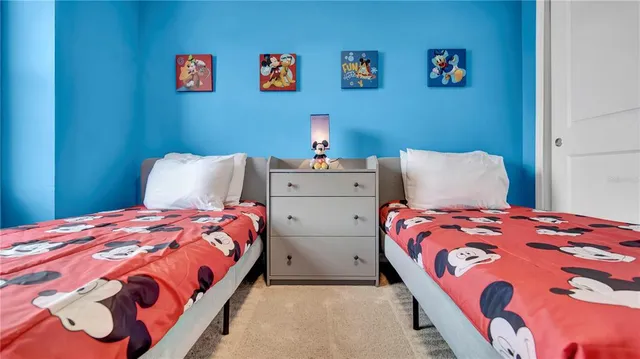 a bedroom with two beds and a painting on the wall