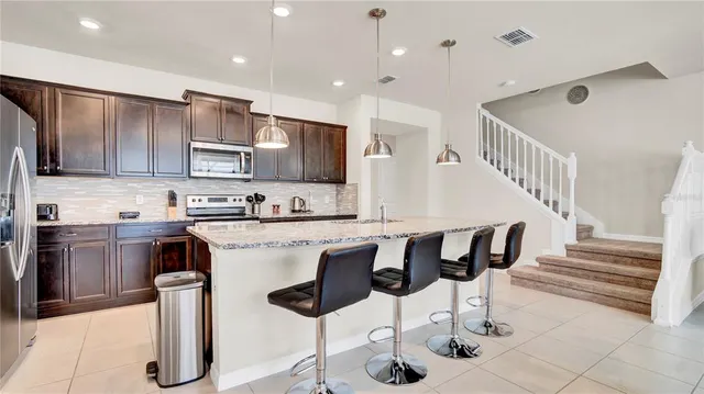 a kitchen with stainless steel appliances kitchen island granite countertop a sink and cabinets