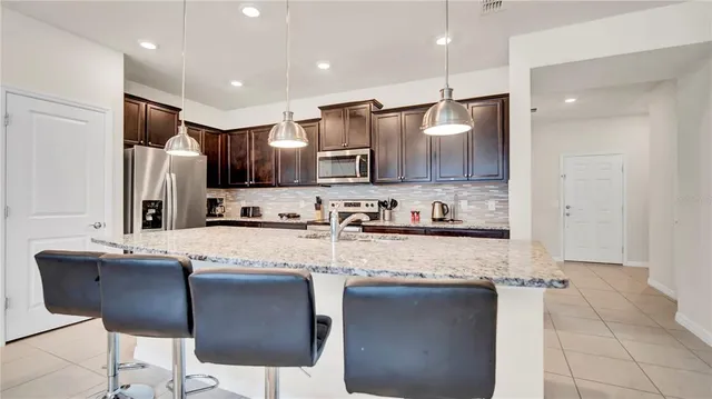 a kitchen with a sink counter top space appliances and a center island
