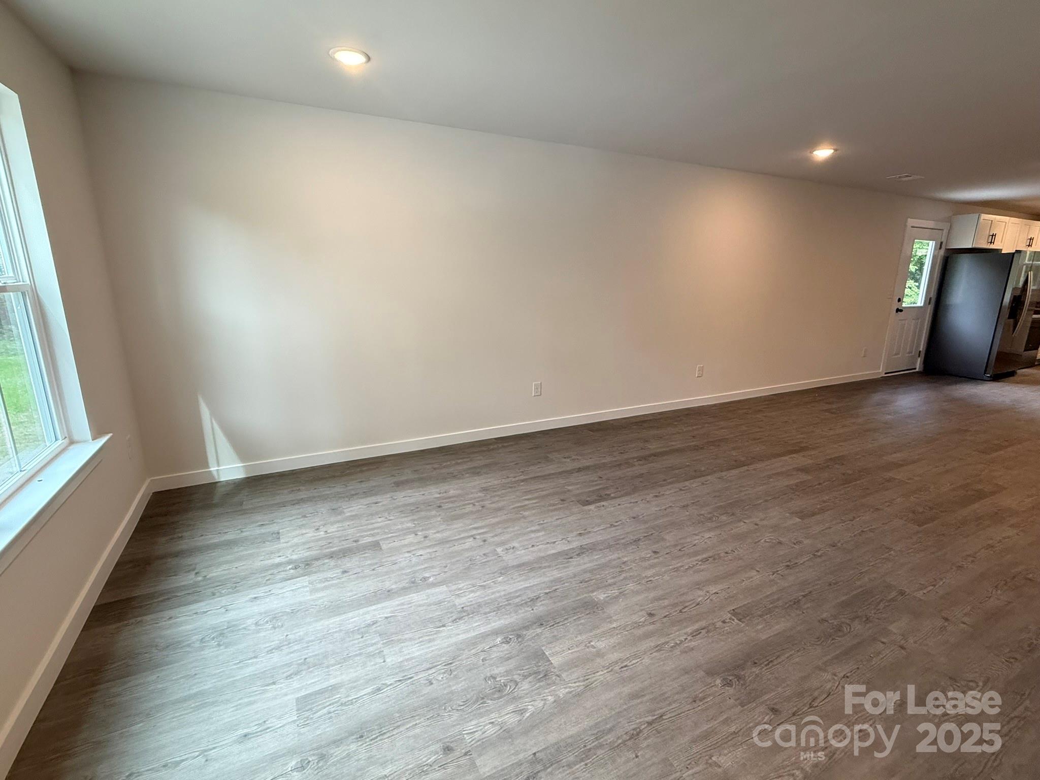 144 33rd Street Northwest, Unit B Hickory, NC 28601 - Photo 3 of 14 an empty room with wooden floor and windows