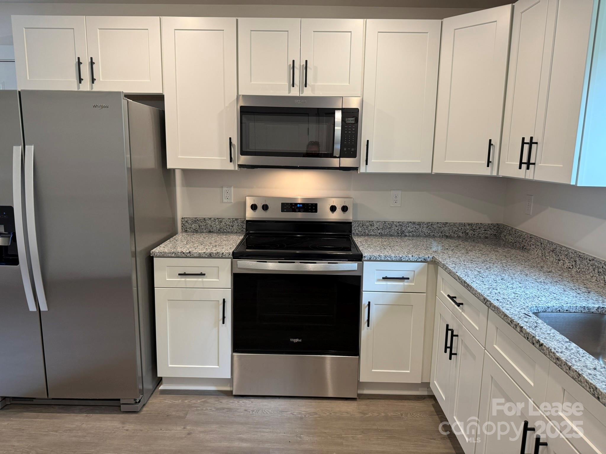 144 33rd Street Northwest, Unit B Hickory, NC 28601 - Photo 6 of 14 a kitchen with stainless steel appliances granite countertop a refrigerator stove and microwave