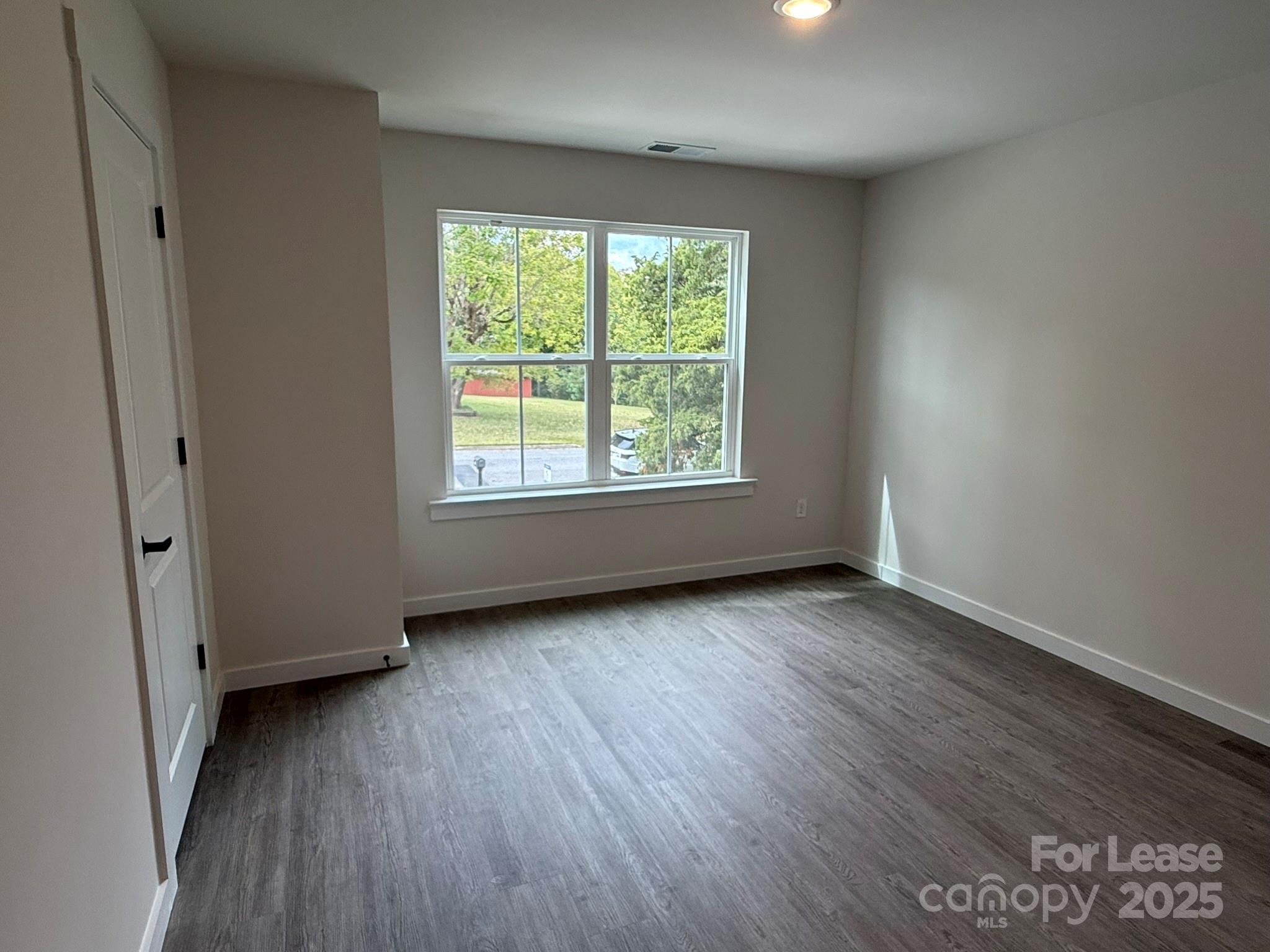 144 33rd Street Northwest, Unit B Hickory, NC 28601 - Photo 8 of 14 an empty room with wooden floor and windows