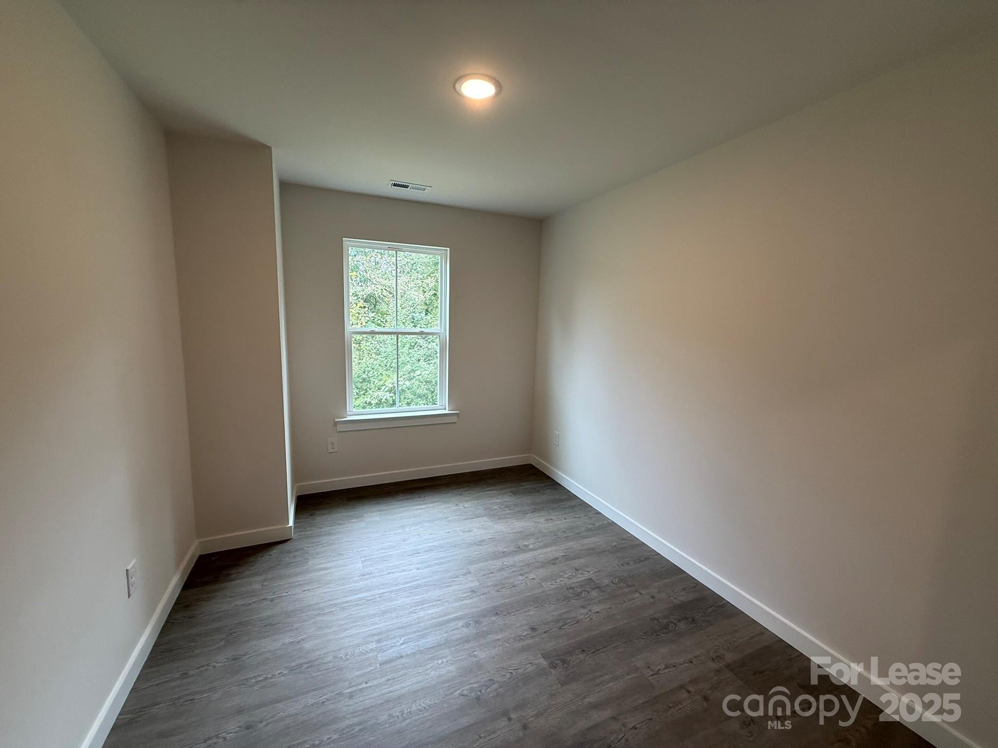 144 33rd Street Northwest, Unit B Hickory, NC 28601 - Photo 10 of 14 an empty room with wooden floor and windows