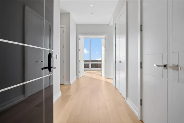 a view of a hallway with wooden floor and staircase