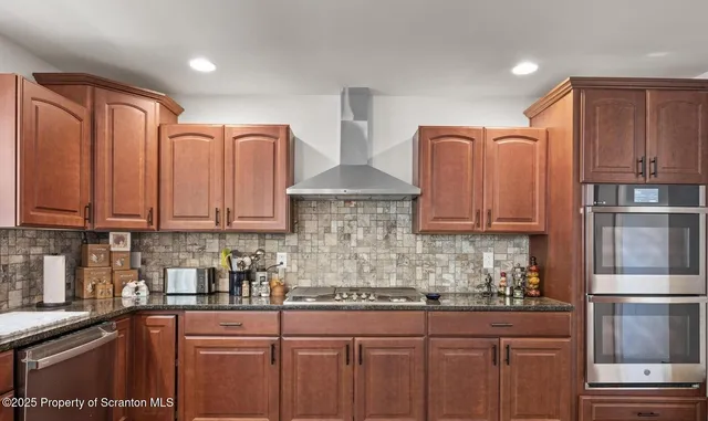 a kitchen with stainless steel appliances granite countertop a sink stove and refrigerator