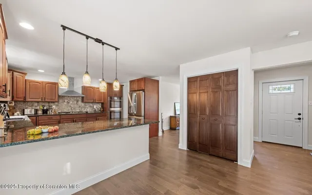 a kitchen with stainless steel appliances a refrigerator and a stove top oven