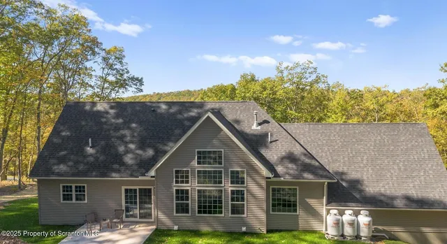 a front view of a house with a yard and potted plants