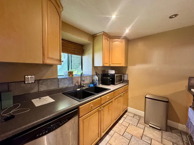 a kitchen with granite countertop a refrigerator and a sink