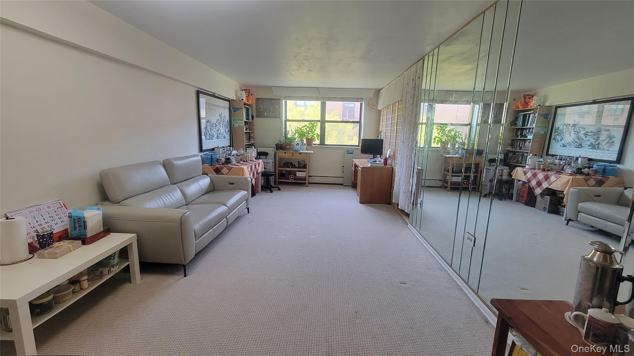 99-30 59th Avenue, Unit 5A Queens, NY 11368 - Photo 1 of 15 a living room with furniture and a large window