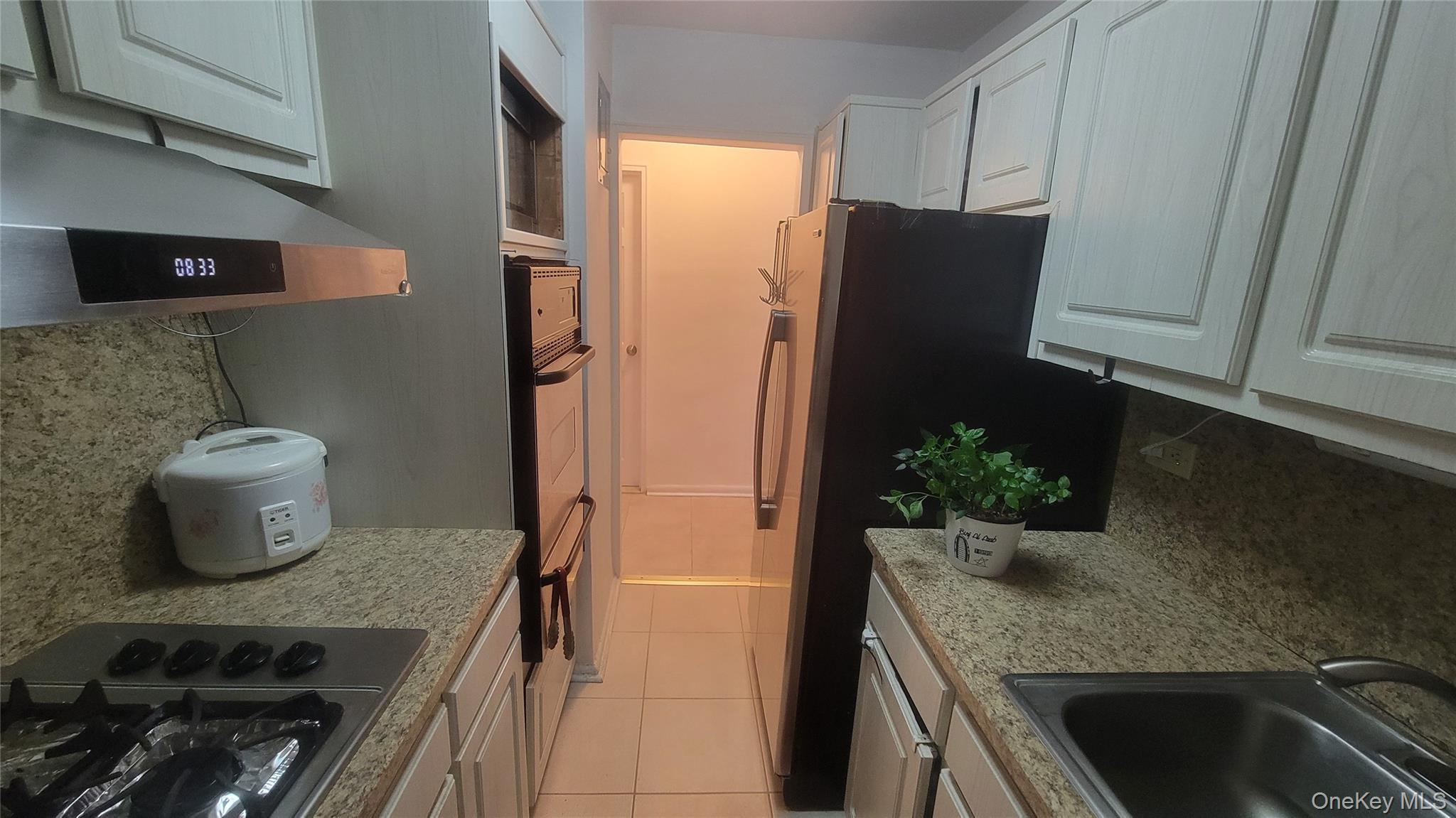 99-30 59th Avenue, Unit 5A Queens, NY 11368 - Photo 2 of 15 a kitchen with a sink and refrigerator
