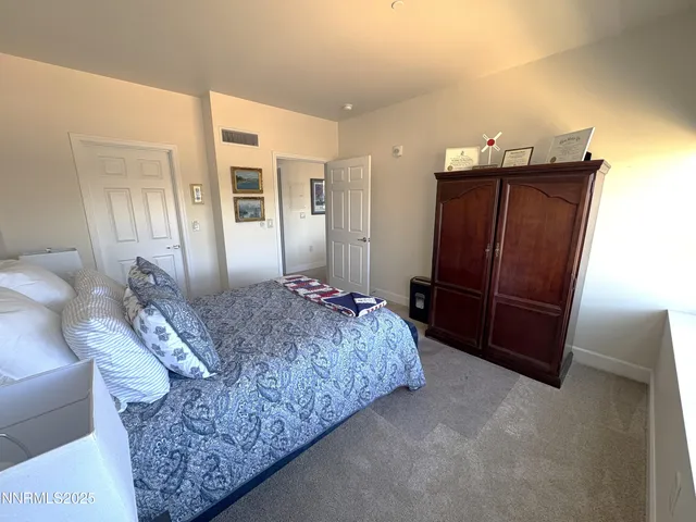 a spacious bedroom with a bed and a dresser