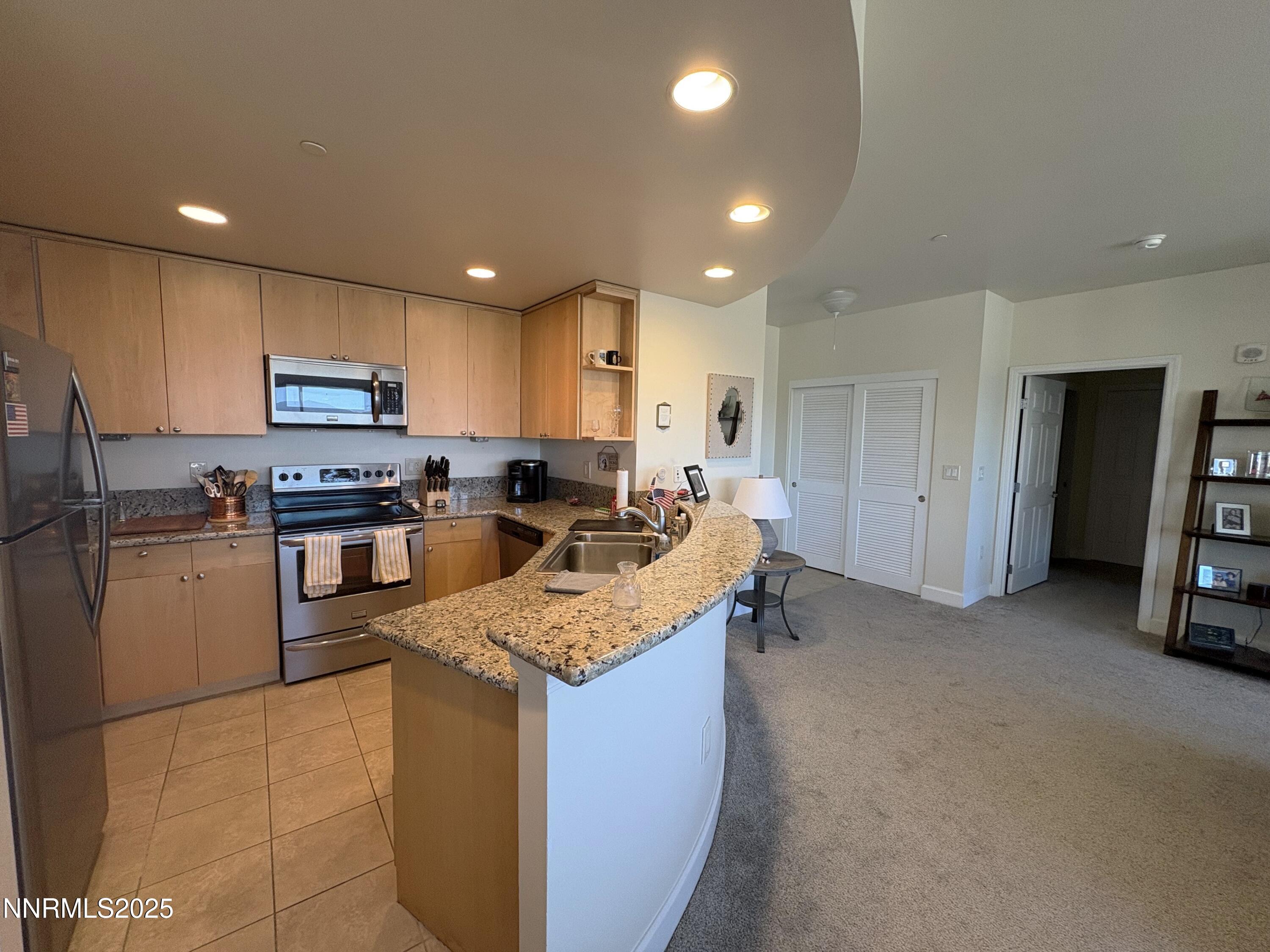 450 North Arlington Avenue, Unit 1207 Reno, NV 89503 - Photo 6 of 21 a kitchen with stainless steel appliances granite countertop a stove top oven a sink and a refrigerator