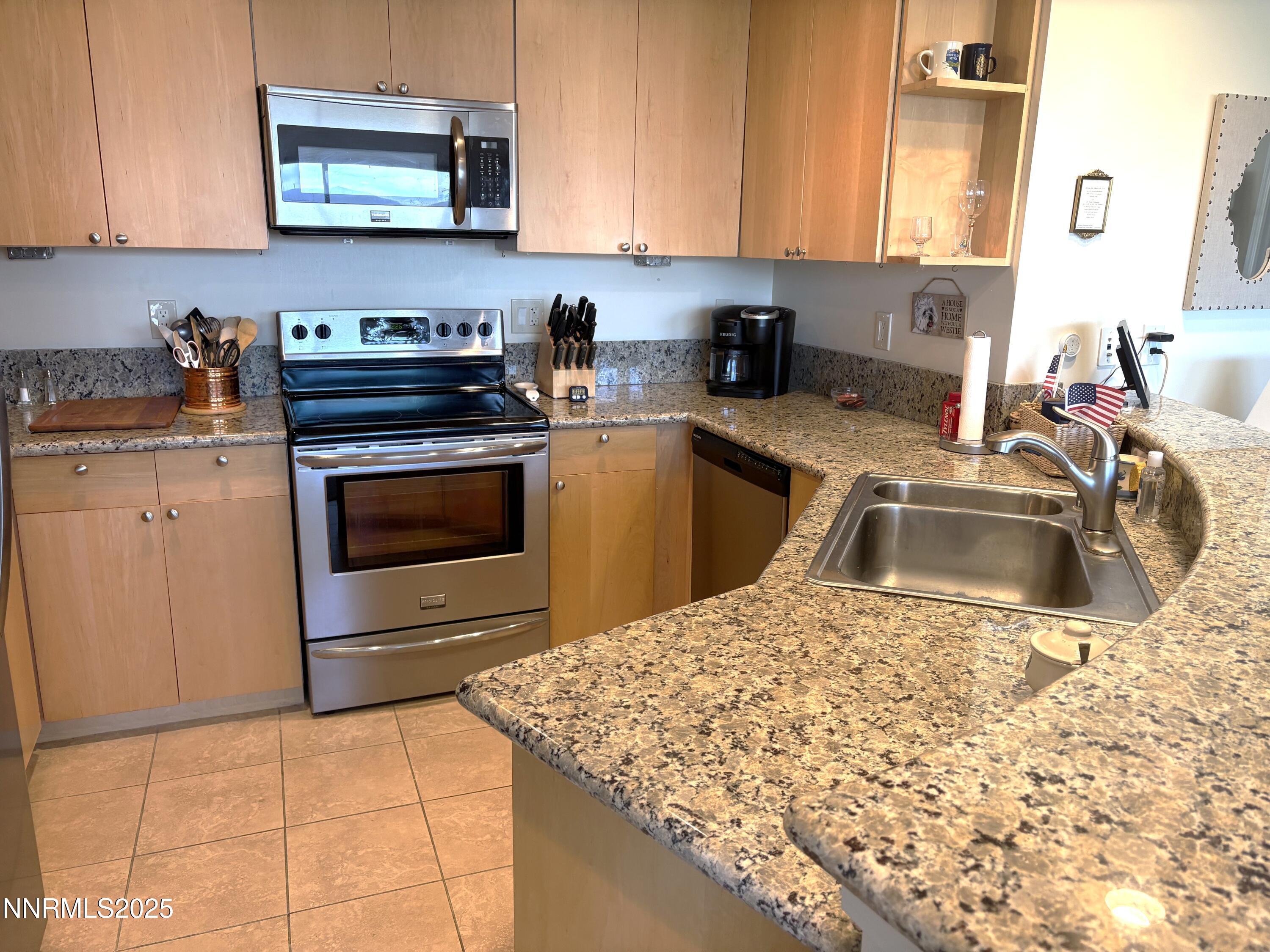 450 North Arlington Avenue, Unit 1207 Reno, NV 89503 - Photo 9 of 21 a kitchen with stainless steel appliances granite countertop a sink stove and cabinets