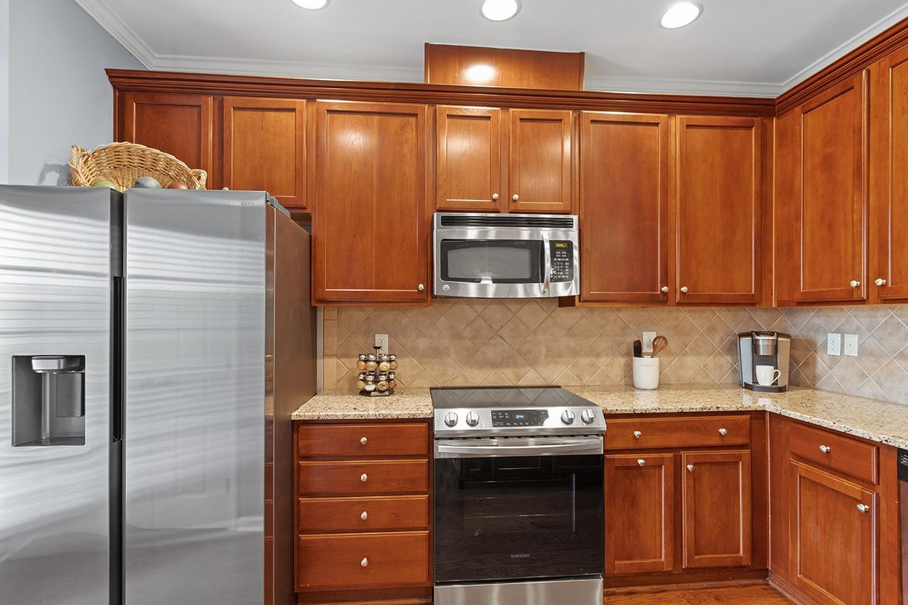 9242 Wooden Road Raleigh, NC 27617 - Photo 13 of 32 Plenty of kitchen storage with 42" upper cabinets and TWO pantries! Waste no space w/the EZ Kitchen upgrade including roll-out trash/recycle cans, roll-out storage shelving in lower cabinets, tilt-out storage for sponge, stopper & DWpods at kitchen sink. Kitchen Cabinets