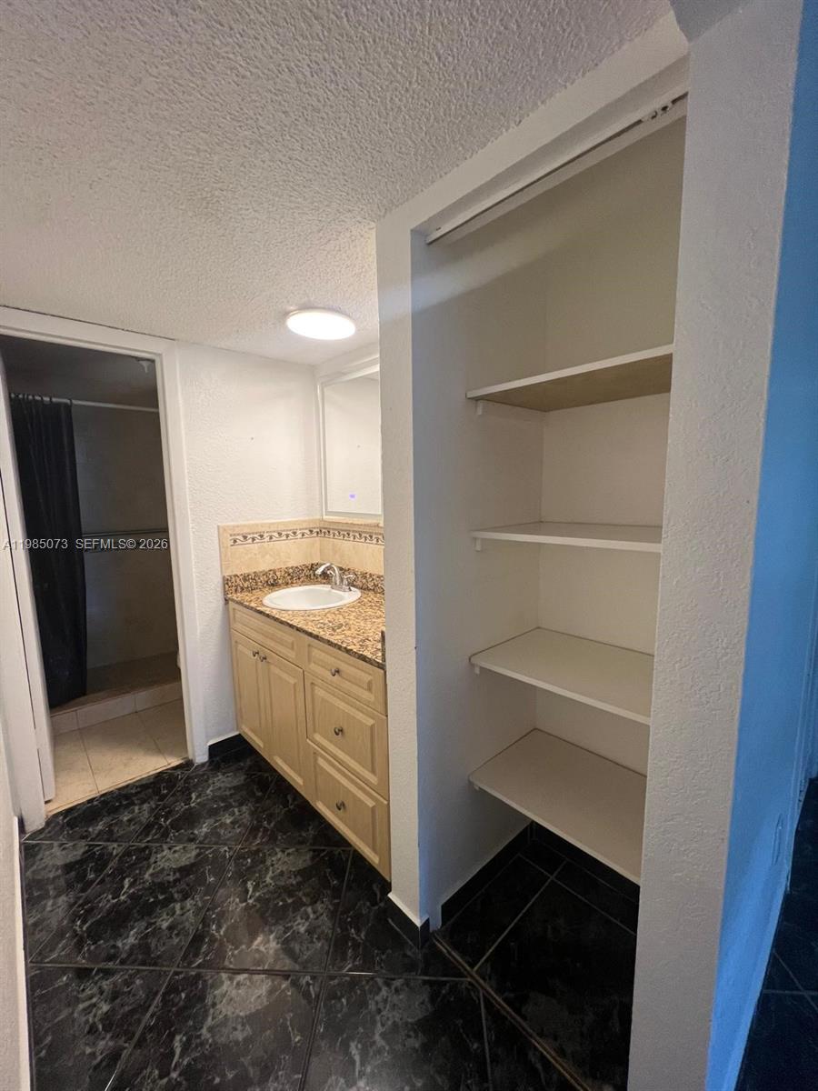 1900 West 68th Street, Unit D207 Hialeah, FL 33014 - Photo 26 of 33 a kitchen with a refrigerator and white cabinets