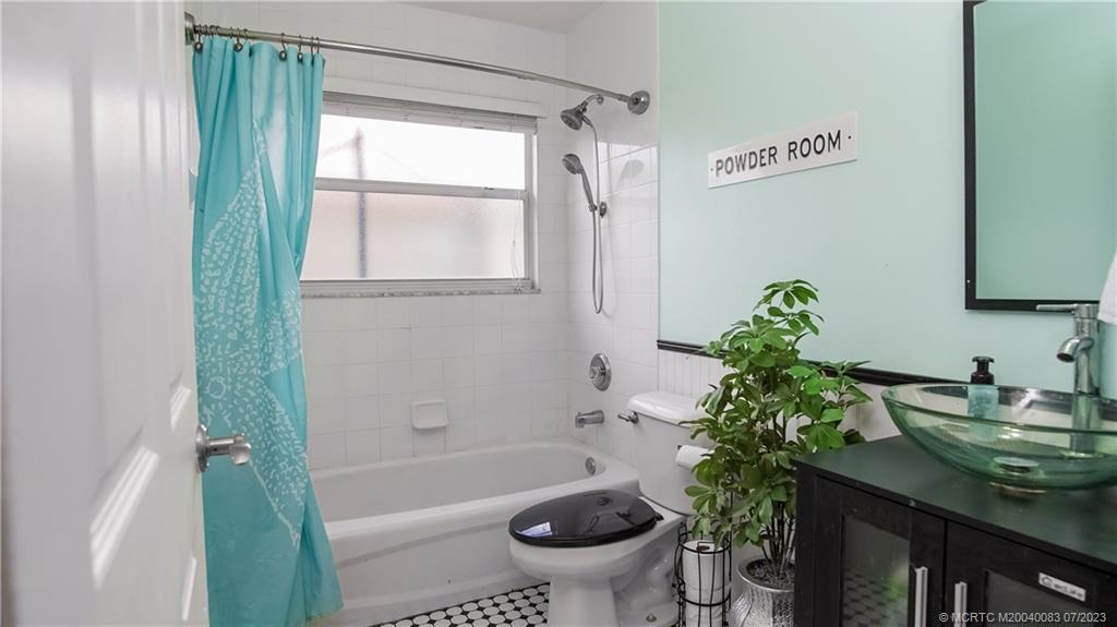 2440 Southwest Riviera Road Stuart, FL 34997 - Photo 12 of 18 a bathroom with a tub sink and toilet