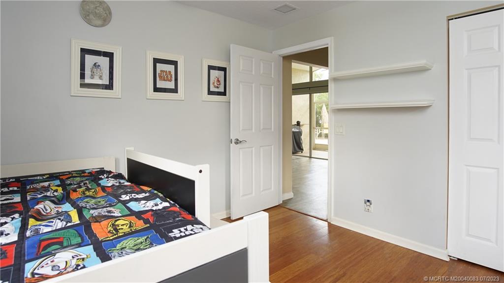 2440 Southwest Riviera Road Stuart, FL 34997 - Photo 14 of 18 a bedroom with a bed and wooden floor