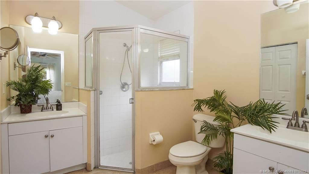 2440 Southwest Riviera Road Stuart, FL 34997 - Photo 9 of 18 a bathroom with a sink a toilet a large mirror and shower
