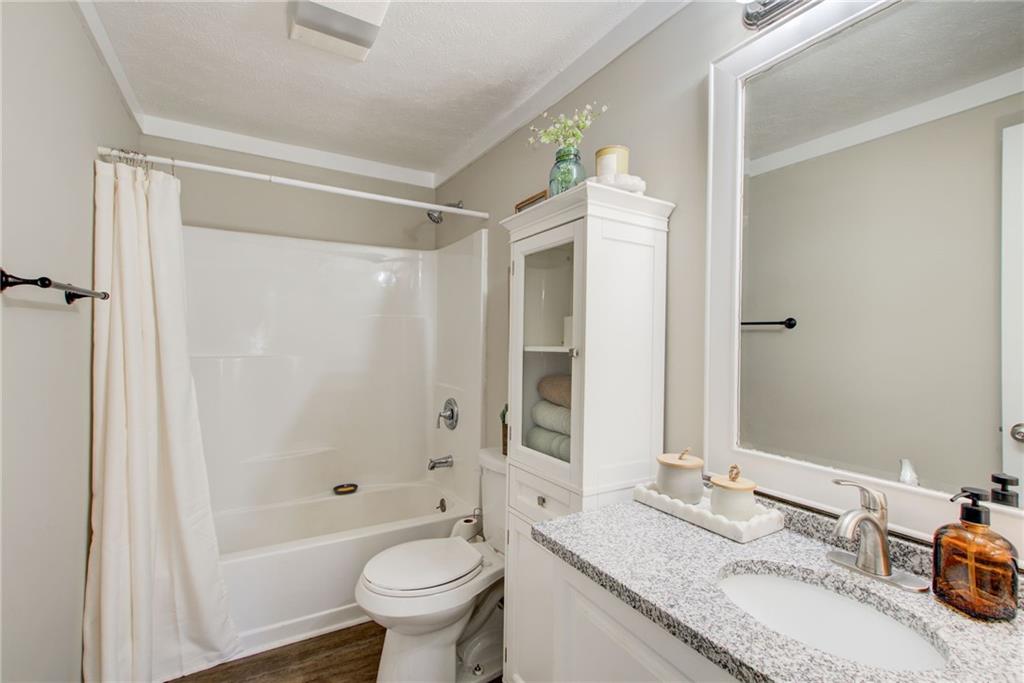 411 Ash Street Monroe, GA 30655 - Photo 19 of 36 a bathroom with a granite countertop sink toilet and shower