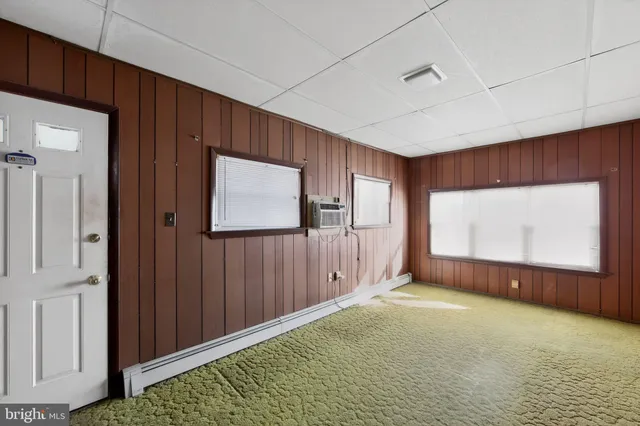 a view of an empty room with window and closet area