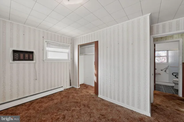 a view of a livingroom with wooden floor and bathroom