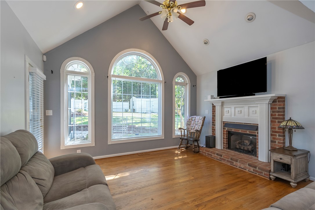 151 Hannah Circle Anderson, SC 29621 - Photo 21 of 46 This living area features a fireplace with a mantel, vaulted ceilings, and hardwood flooring.