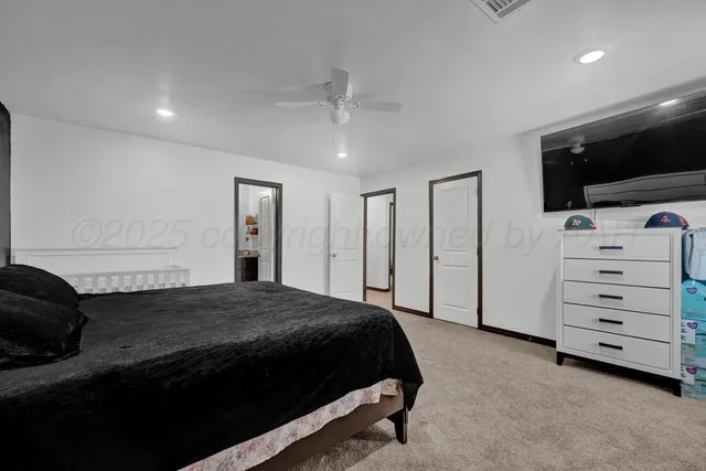 a bedroom with a bed and a flat tv screen on wall