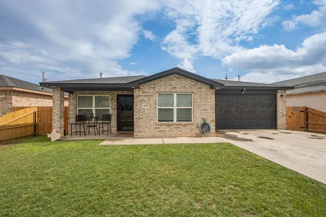 a front view of a house with a garden and yard