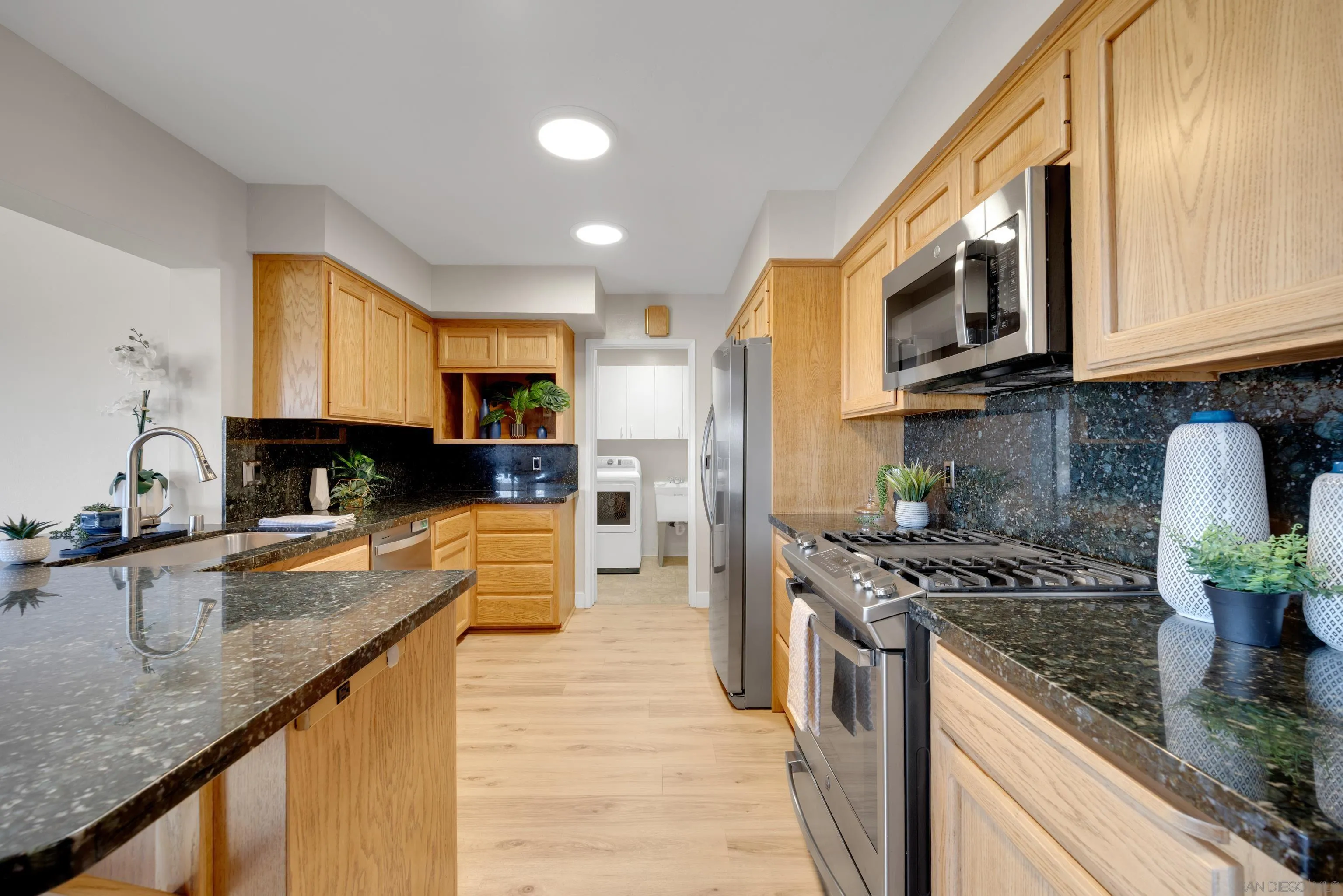 13710 Ahwahnee Way Poway, CA 92064 - Photo 11 of 43 a kitchen with stainless steel appliances granite countertop a stove a sink a microwave and refrigerator