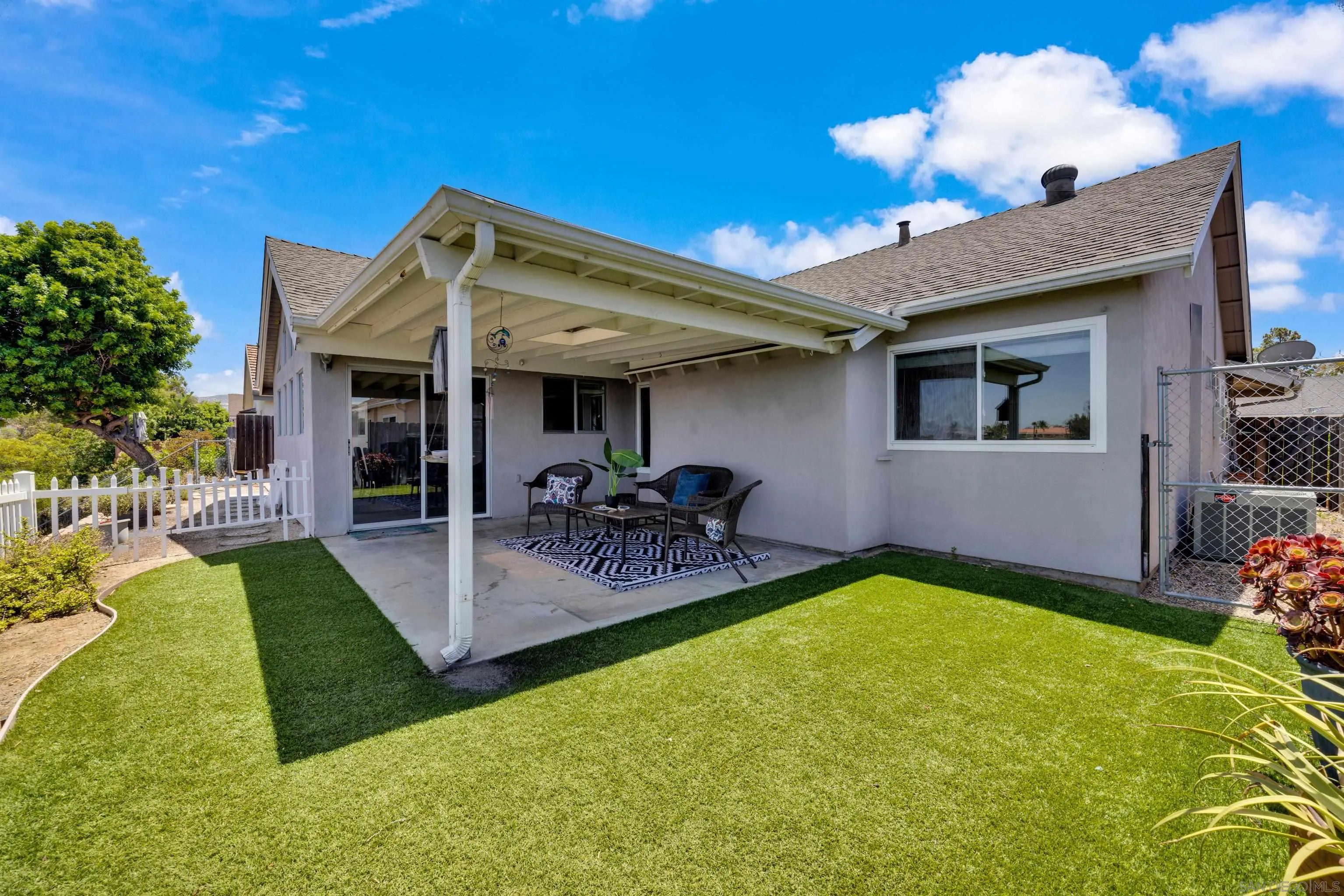 13710 Ahwahnee Way Poway, CA 92064 - Photo 32 of 43 a view of a patio with dining table and chairs with plants and wooden fence