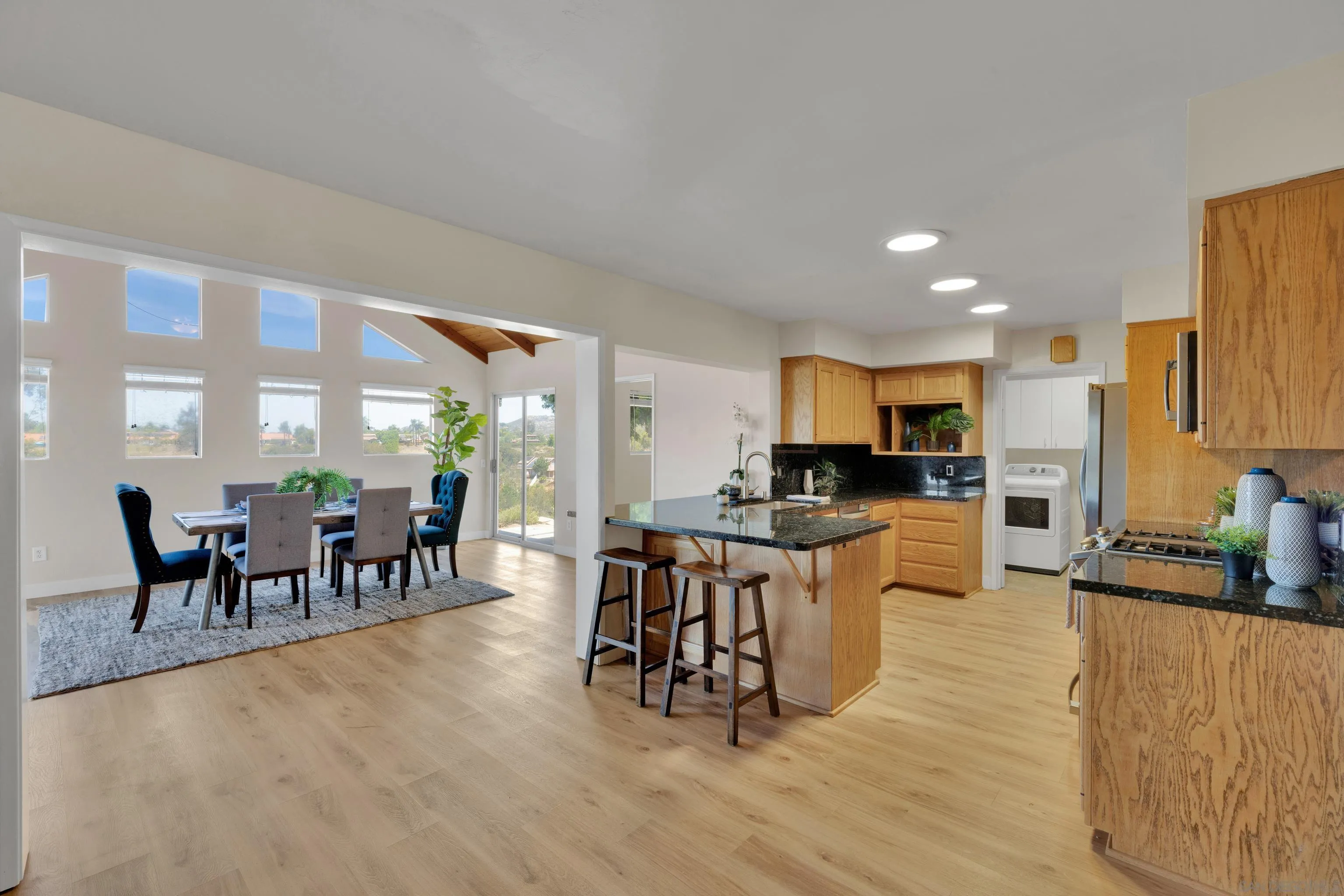 13710 Ahwahnee Way Poway, CA 92064 - Photo 9 of 43 a large living room with stainless steel appliances kitchen island granite countertop a dining table chairs and a large window