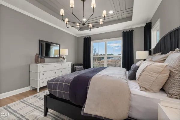 a bedroom with a large bed a flat tv screen and a dresser