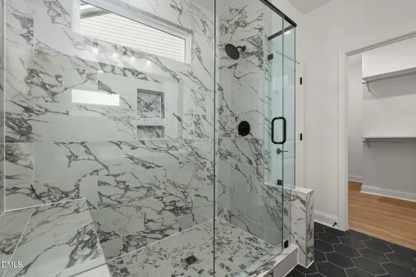 a spacious bathroom with a double vanity sink a mirror a glass door a shower and a mirror