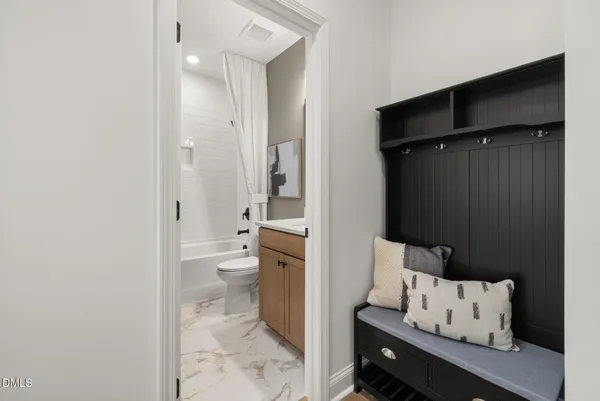 a hallway with wooden floor windows and a bathroom