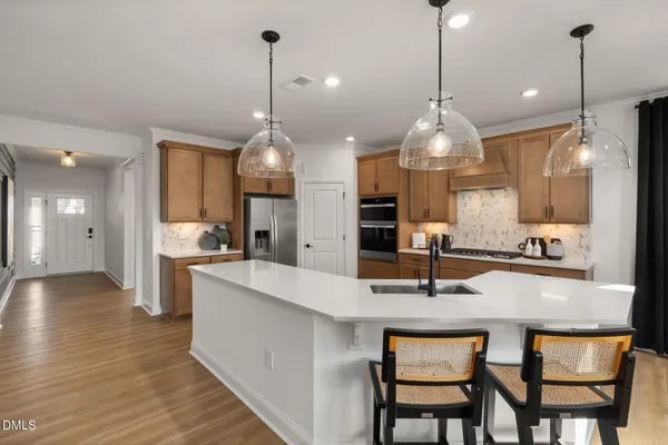 a kitchen with stainless steel appliances kitchen island granite countertop a sink stove and refrigerator
