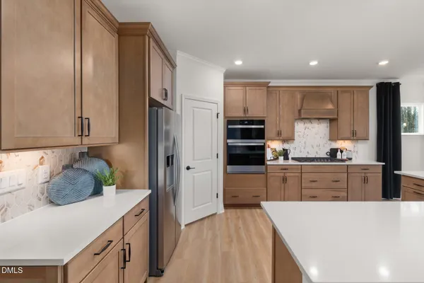a kitchen with stainless steel appliances kitchen island granite countertop a table chairs and a sink
