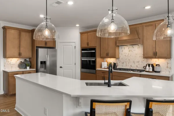 a kitchen with stainless steel appliances kitchen island granite countertop a refrigerator and a stove top oven