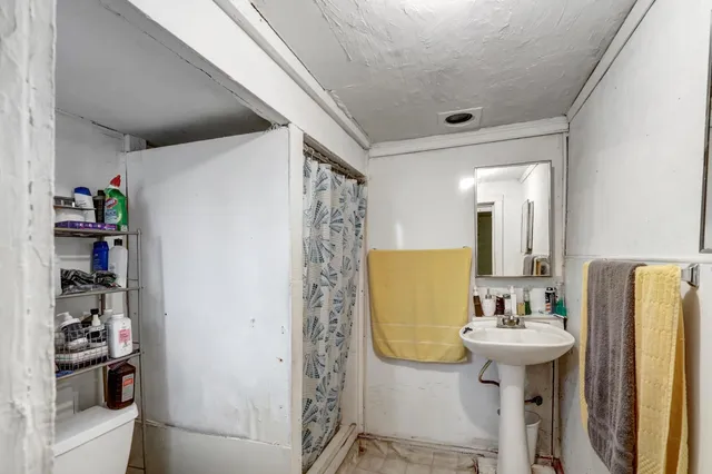 a bathroom with a sink a mirror a toilet and a shower