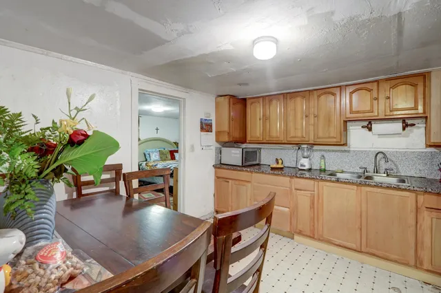 a kitchen with granite countertop a table chairs stove and cabinets