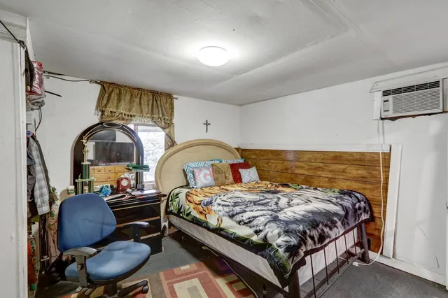 a bedroom with a bed a dresser and chair