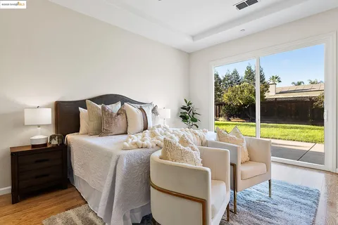 a bedroom with a bed and a potted plant on the dresser