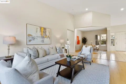 a living room with furniture and a painting on the wall