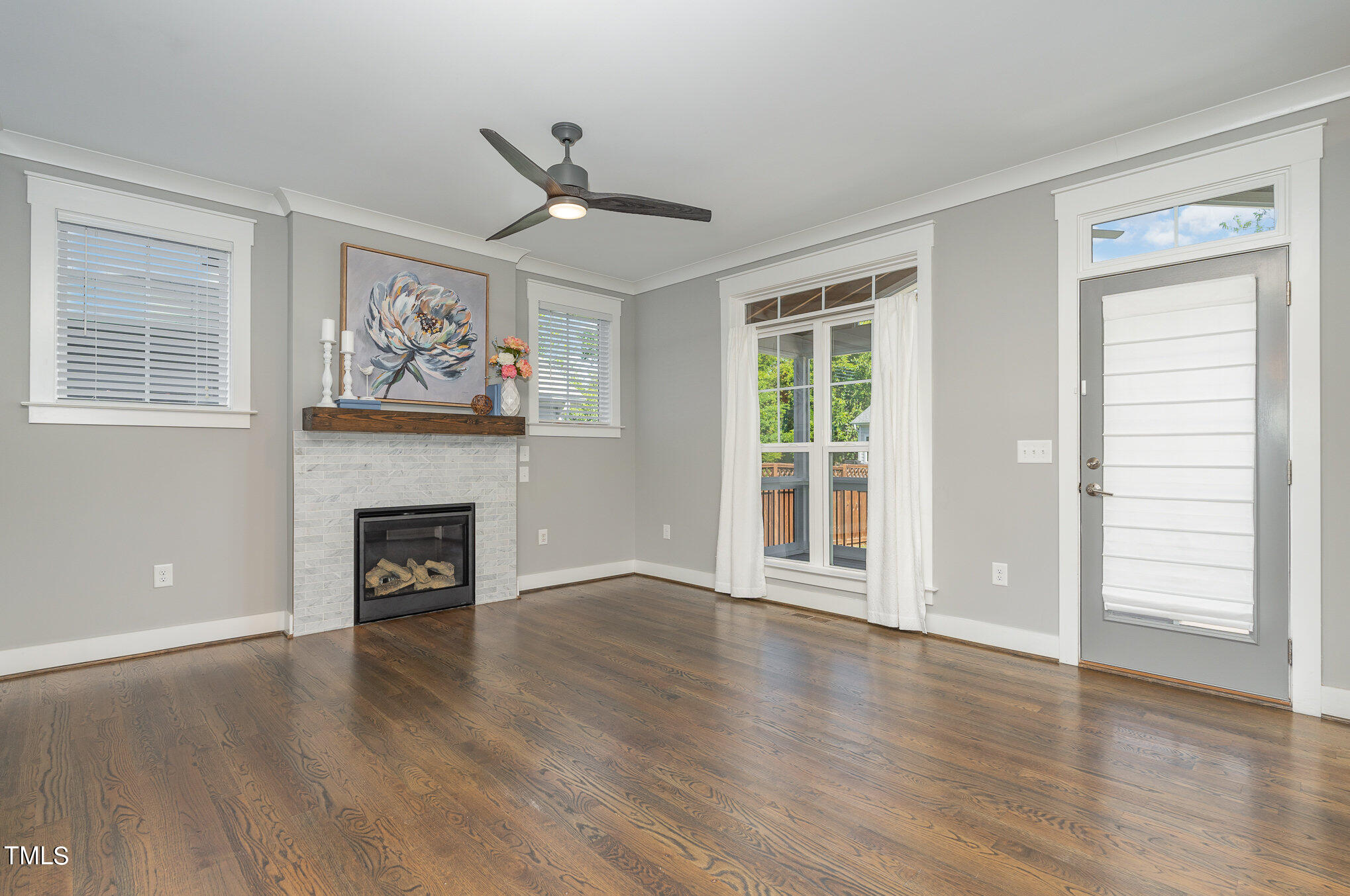 719 East Lenoir Street Raleigh, NC 27601 - Photo 3 of 16 an empty room with wooden floor a ceiling fan and a window