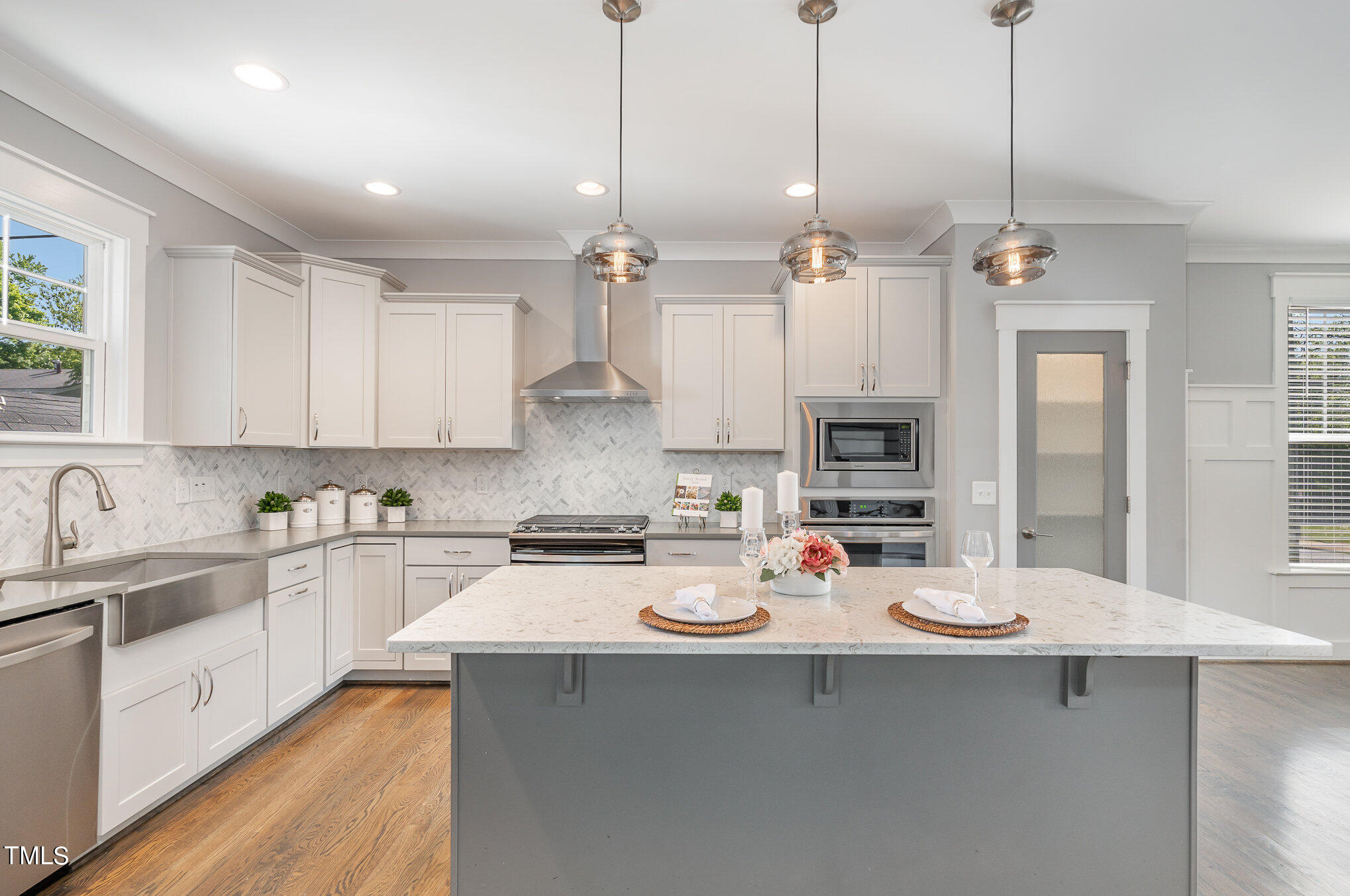 719 East Lenoir Street Raleigh, NC 27601 - Photo 5 of 16 a kitchen with stainless steel appliances kitchen island granite countertop a sink dishwasher white cabinets and a dining table with wooden floor